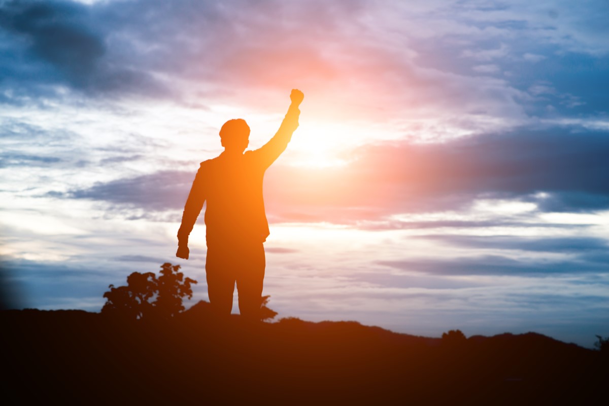Raised arms man against beautiful sunset